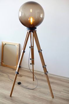 a lamp that is on top of a tripod in the middle of a room