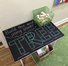 a sign that reads build this word using blocks to write the words tree on it