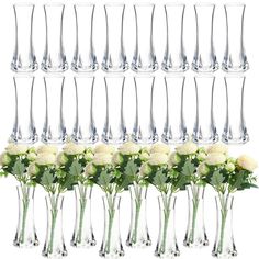 a bunch of wine glasses filled with white roses and greenery in front of each other