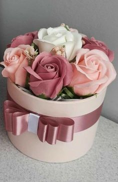 a pink and white hat box with roses in it