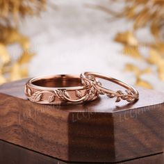 two wedding rings sitting on top of a wooden box