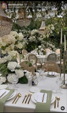 the table is set with white flowers and place settings for an elegant dinner party or celebration