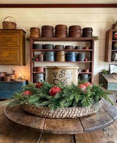 a wooden table topped with a basket filled with christmas decorations