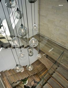 an overhead view of a wooden staircase with glass globes hanging from it's sides