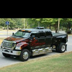 a black pickup truck with flames painted on it's bed is parked in the street