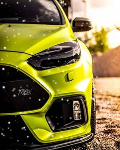 the front end of a lime green car with snow flakes on it's hood