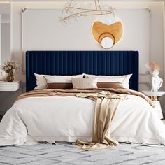 a bedroom with a large blue headboard and white bedding, beige throw pillows