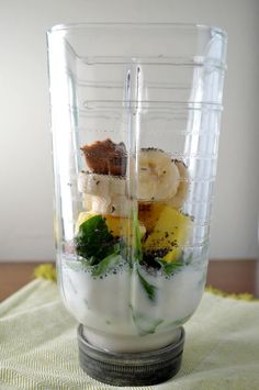 a blender filled with fruit and vegetables on top of a table