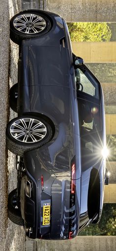 the back end of a blue car with two tires on it