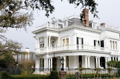 a large white house with lots of windows and balconies on the top floor