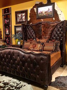 a large bed sitting inside of a bedroom next to a cowhide rug on the floor