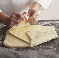 a person kneading dough on top of a table