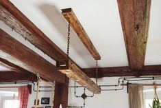 a room with wooden beams and hanging lights