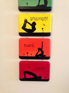 three magnets with yoga images on them are hanging on the wall in front of a door