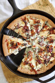 a pizza sitting in a pan on top of a table next to a spatula