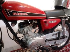 a red motorcycle parked on top of a rug