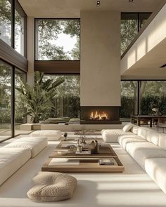 a large living room with white couches and a fire place in the middle of it