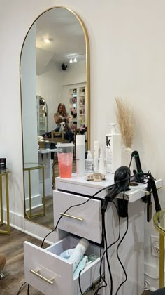 a hair dresser with its drawers open in front of a mirror