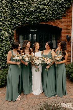 the bridesmaids are all dressed in green dresses and holding their bouquets together