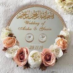 a wedding card with flowers and pearls on the front, in arabic writing is surrounded by roses