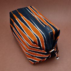 an orange and black striped bag on a brown background