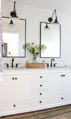 a bathroom with double sinks and two mirrors