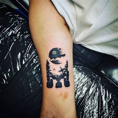 a person with a tattoo on their arm that has an image of the moon and trees