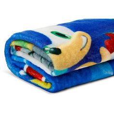 a blue and white blanket with sonic the hedgehog on it is folded up in front of a white background