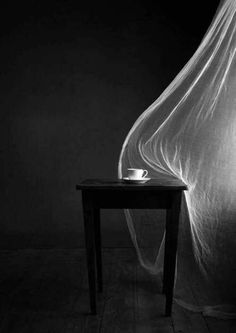 a black and white photo of a table with a cloth draped over it