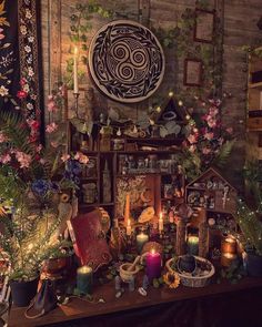 a table topped with lots of plants and candles