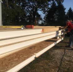 two men are working on the side of a building that is being built with plywood