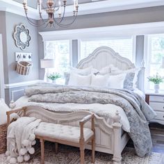 a bedroom with a large bed and chandelier