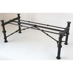 an iron bed frame with four posts and black paint on the top, against a white background