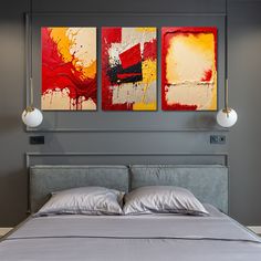 a bed with two paintings on the wall above it