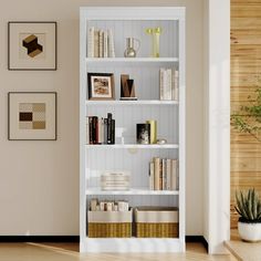 a white book shelf filled with books next to a plant and pictures on the wall