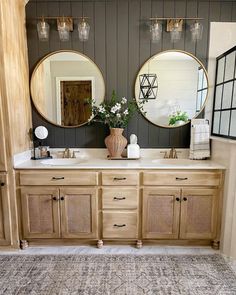 a bathroom with two sinks, mirrors and vases on the counter top next to each other