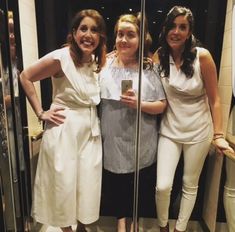 three women are standing in front of a mirror