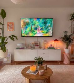 a living room filled with furniture and a flat screen tv mounted to the side of a wall