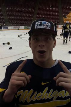 a young man wearing a michigan hockey jersey and hat