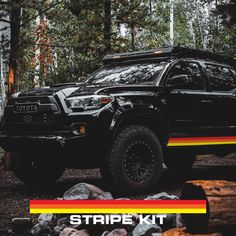 a black truck parked on top of a forest covered in rocks and trees with the words stripe kit written below it