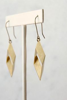 Smart looking geometric drops that are very easy to wear. These are brass rhombus shapes, hanging from nickel free brass hooks. The cut angles catch the light at different points so it really stands out despite being such a simple design.  For stylish geeks at heart.Also available as studs (last photo) here: www.etsy.com/listing/646935849And I have a matching necklace here: www.etsy.com/listing/512818576► DETAILS:Dimensions: 2.75" from top to bottom x .75" wide (7 cm x 1.75 cm)Materials: Raw bra Geometric Jewelry Set, Rhombus Earrings, Geometric Jewelry Design, Rhombus Shape, Brass Hooks, Earrings Minimal, Gold Bar Necklace, Paper Jewelry, Sterling Jewelry