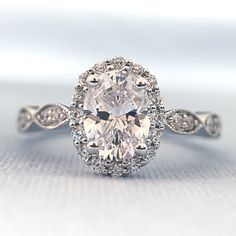 an oval shaped diamond ring with diamonds around it