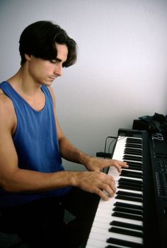 a man sitting at a piano with his hands on the keys