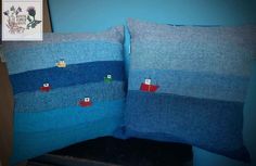 two blue pillows with small boats on them