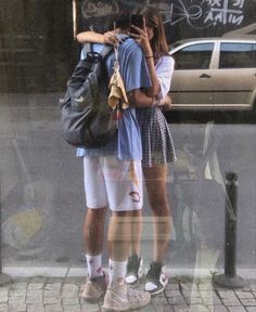 two people standing in front of a store window