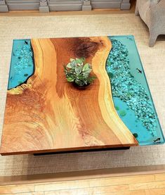 a wooden table with blue glass in the center and a plant sitting on top of it