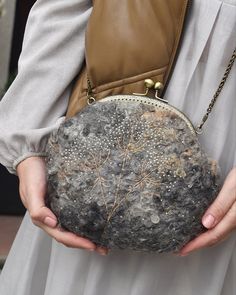 a woman holding a purse with trees on it