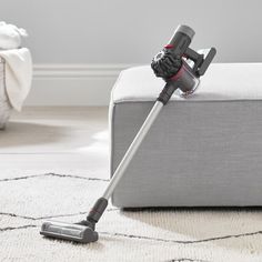 a close up of a vacuum cleaner on the floor in a room with white rugs