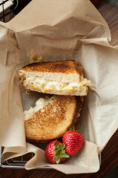 a grilled cheese sandwich in a basket with strawberries