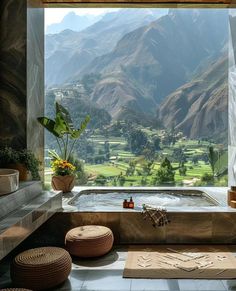 an outdoor jacuzzi tub with mountains in the background and flowers on the floor